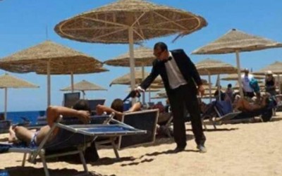 Egyptian hotel entertainer holds a fake gun to the heads of British tourists